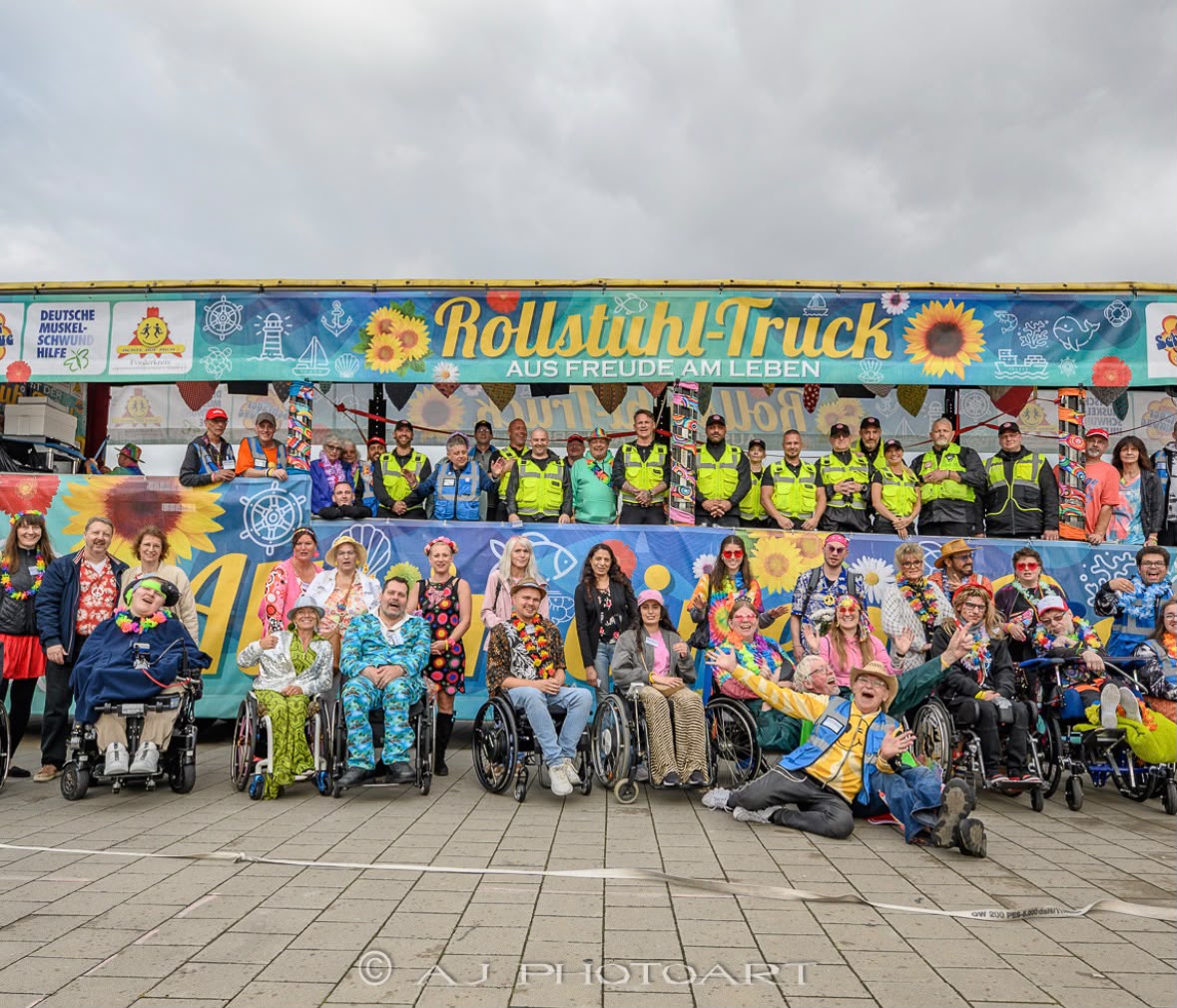 Gruppenbild von den Personen, die auf dem Rollstuhl-Truck mitgefahren sind und dem Helfer-Team.